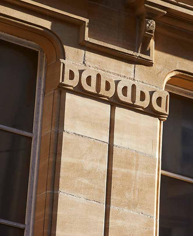 Frise sculptée en pied de façade